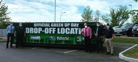Subaru employees in front of a trash dumpster